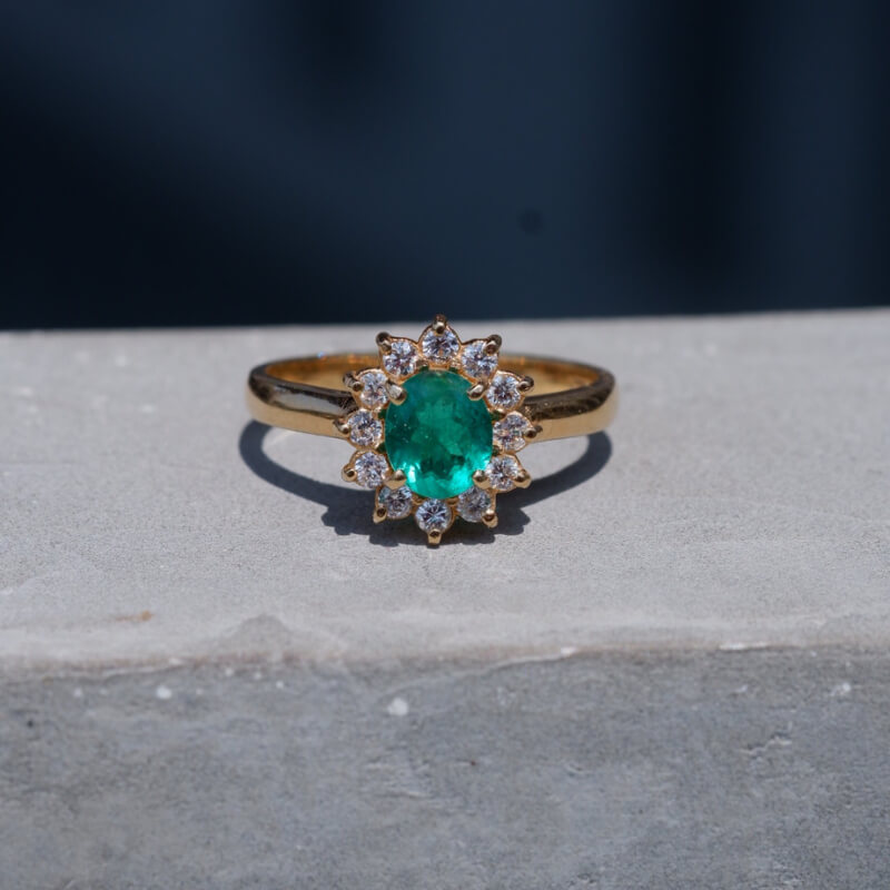 Anillo esmeralda colombiana con halo de diamantes, material oro 18k amarillo.