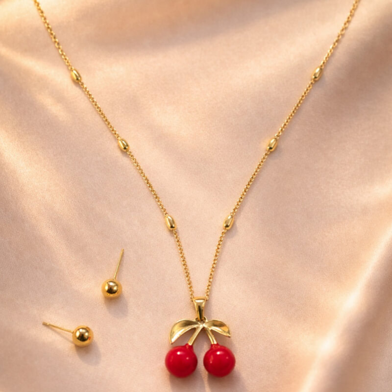 COLLAR DORADO CON CEREZA + ARETES ESFERA